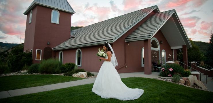 bride with bouquet in fron of wedding chapel in Colorado